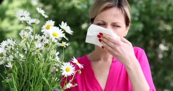 花粉症の若い女性は カモミールの花4K映画の近くのナプキンで彼女の鼻を吹いています アレルギー疾患の概念 — ストック動画