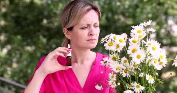花粉症の女はカモミールの花の匂いがし 4K映画の外にバイアルで滴下鼻を滴下 季節性アレルギーと気管支喘息の概念 — ストック動画