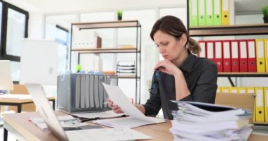 Kadın yönetici, modern önermelerle masa imzalamak için sözleşmeyi dikkatlice inceler. Kadın ofis çalışanı kadehleri ağır çekimde tutan verileri kontrol ediyor.