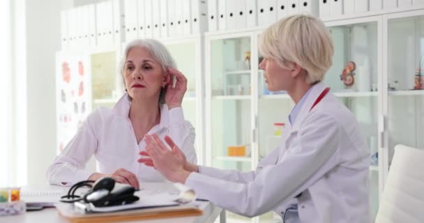 Mulher Madura Paciente Mostra Ouvido Doente Médico Sentado Mesa Consultório — Vídeo de Stock