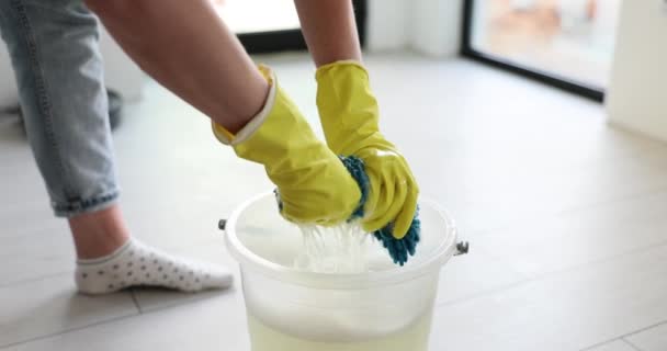 女清洁员戴着橡胶手套 把拖把破布放在水桶上 放在光室里 清洗湿气 保持工作间的卫生 — 图库视频影像
