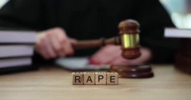 Hakimin tokmağa vurmasına karşı tahta küplerden yapılmış kelime tecavüzü. Ağır çekimde cinsel saldırı ve şahıslara yönelik şiddet yargılaması