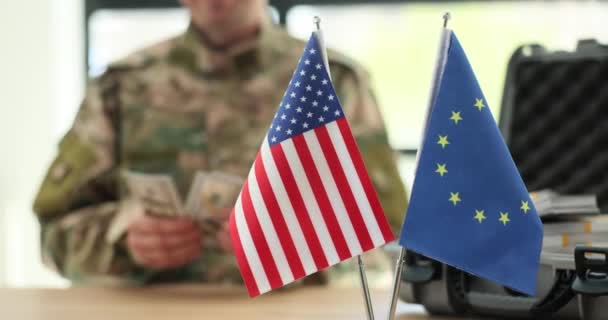 Militäroffizier Zählt Dollarnoten Die Neben Amerikanischen Und Europäischen Flaggen Tisch — Stockvideo