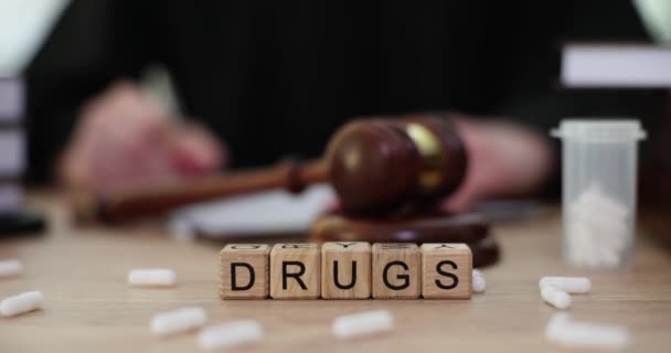 用木立方体对着木槌制成的字谜药 并在散落在桌上的药丸附近进行判断 关于非法分销和消费毒品的判决 — 图库视频影像