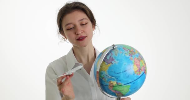 Позитивна Жінка Тримає Земну Кулю Грає Іграшковим Літаком Світлому Фоні — стокове відео