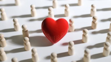 Kalabalığın arasında kırmızı oyuncak bir kalp. Nüfus kavramı için kardiyoloji bakımı