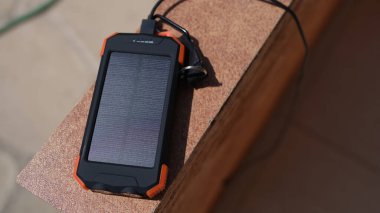 Güneş enerjisi bankası, güneş ışınlarının altında duran cep telefonunu şarj etmek için kullanılıyor. Taşınabilir güneş pili
