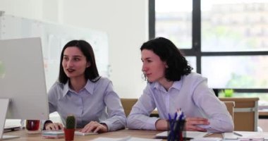 Birkaç çalışan karmaşık projeyi bitirmekten memnun. Genç adam ve kadın gülüp el sallayarak zaferle ofiste ağır çekimde oturuyor.