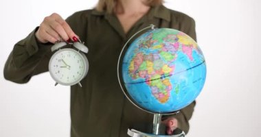 Kadının arka planında klasik çalar saat ve küre var. Çevre aktivisti Dünya saatiyle ilgileniyor. Çevre koruma kavramı