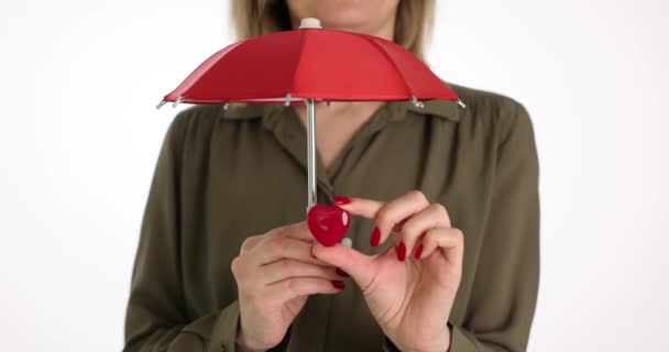 Žena Zakrývá Malé Srdce Červeným Deštníkem Lehkém Studiu Zdravotní Pojištění — Stock video
