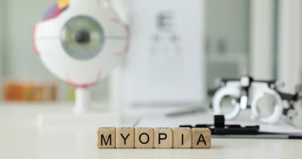 Słowo Myopia Drewnianych Klocków Przeciwko Okulary Egzaminacyjne Model Gałki Ocznej — Wideo stockowe