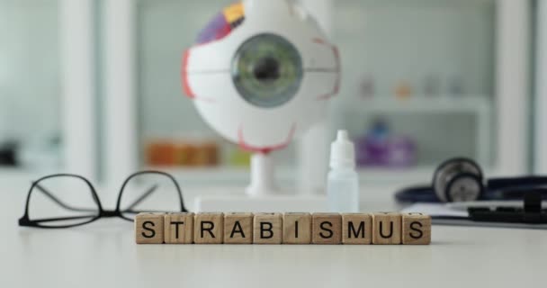 Word Strabismus Przeciwko Modelowi Gałki Ocznej Sprzętowi Okulistycznemu Lekkim Stole — Wideo stockowe