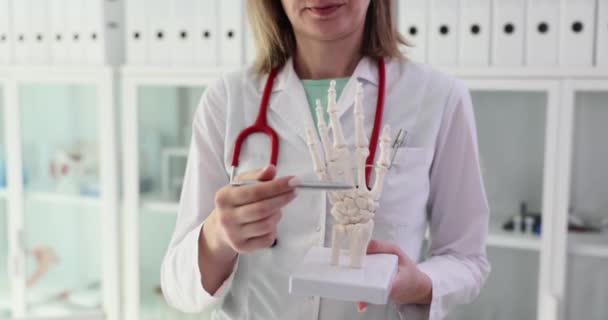 Mulher Médico Aponta Caneta Mão Esqueleto Demonstrando Modelo Consultório Clínica — Vídeo de Stock