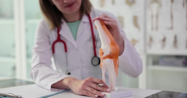 Mujer Médico Explica Trabajo Articulación Rodilla Modelo Esqueleto Sentado Escritorio — Vídeos de Stock