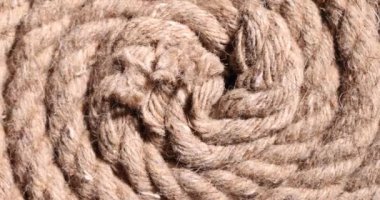 Yüzeyde bükülmüş güçlü kahverengi bir ip var. Güneş ışığında eskimiş kenevir malzemesinden yapılmış klasik yelkenli ipi. Tırmanma ve demirleme ekipmanları