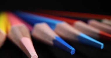 Siyah arka planda çok renkli sivri uçlu kalem uçları. Çocuklar ve yetişkinler için çizim ve öğrenim amaçlı kırtasiye malzemesi. Sanatçı konsepti aracı