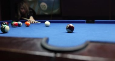 Kadın oyuncu bilardo masasında topu cebe atmak için topa vuruyor. Top hedefi ıskaladı. Eğlence ve oyun konsepti yavaş çekim