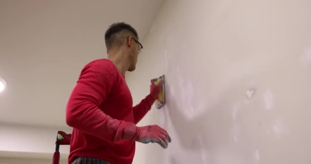 Właściciel Mieszkania Rękawiczkami Poleruje Ściany Gipsowo Kartonowe Pokoju Mężczyzna Usuwa — Wideo stockowe