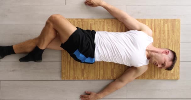 Homem Faz Exercício Relaxante Deitado Junco Matting Colocar Piso Laminado — Vídeo de Stock