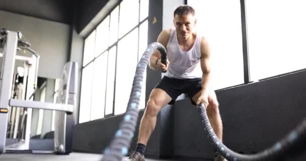 Позитивный Человек Делает Эффективные Упражнения Тяжелыми Боевыми Канатами Стоящими Рядом — стоковое видео
