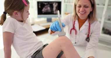 Doktor travmatolog, çocuk dizinin ultrason muayenesini klinikte yapıyor. Eklemlerde ağrı ve çocuklarda menisküs