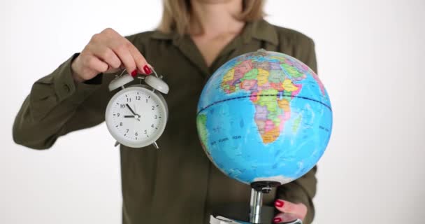 女人拿着闹钟和全球的闹钟 使地球免受全球变暖和污染的影响 — 图库视频影像