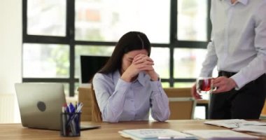 Meslektaşları kadınları destekliyor ve çay getiriyor. Takım arkadaşı, üzgün bayan meslektaşını rahatlatıyor.