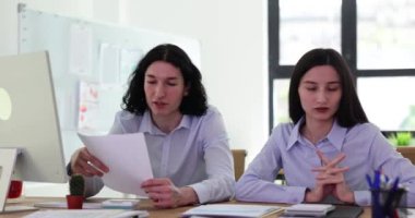 Modern ofiste birlikte çalışan bir grup öğrenci. Kadın iş arkadaşıyla yeni bir başlangıç projesi ve belgeler hakkında konuşuyor.