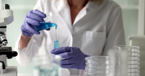 Asystent Laboratoryjny Wlewa Niebieską Substancję Chemiczną Probówki Badania Naukowe Przemyśle — Wideo stockowe