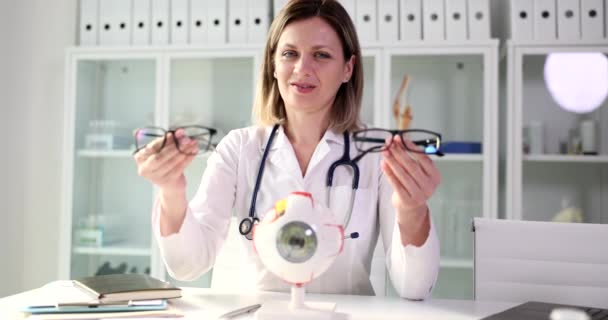 Oftalmolog Håller Olika Glasögon Händerna Läkarmottagningen Läkaren Rekommenderar Glasögon För — Stockvideo