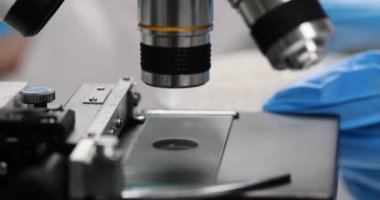 Bilim adamı laboratuvarda mikroskop altında şeker kristallerini inceliyor. Kristal madde üzerine tıbbi araştırma