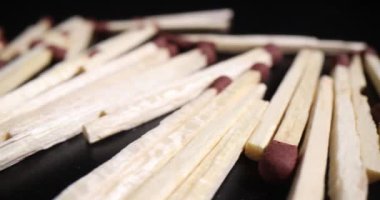 Koyu arkaplanda bir yığın tahta kibrit. Ahşap kibritler ateş yakmak ya da yemek pişirmek için
