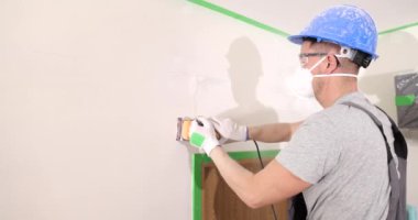Usta 'nın elindeki duvar macunuyla bitirme işi yıpratıcı. Boyamadan önce duvarlar yıkılıyor