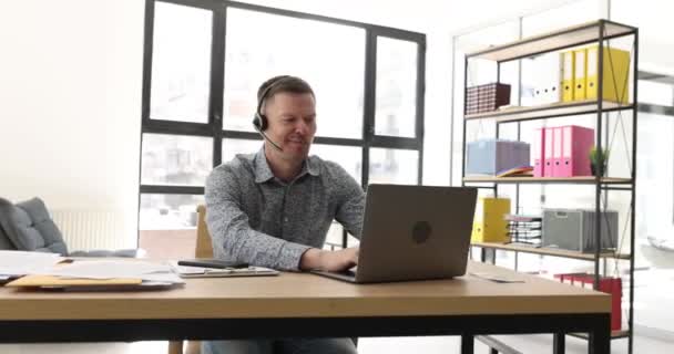 Glimlachende Mannelijke Operator Headset Kijken Naar Laptop Scherm Tijdens Het — Stockvideo