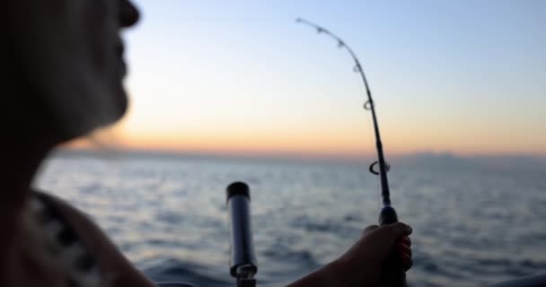女人在日落时带着钓竿捕鱼 为游客捕鱼 — 图库视频影像