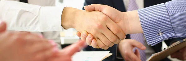 Welcome to our team and conclusion of business contract. Business people shaking hands while working in creative office