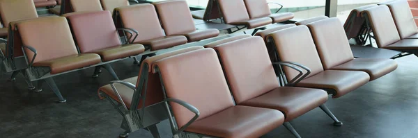 Departure hall at airport with leather seats in row. Interior design airport station concept