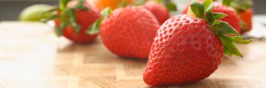 Fresh juicy strawberries and fruits on board. Vitamins and benefits of berries concept
