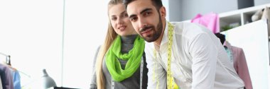 Two young stylists of the designer communicate in atelier. Training in tailoring concept