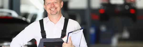 修理中の自動車を受け入れる若い自動車整備士を笑顔 カーワークショップサービスコンセプト — ストック写真