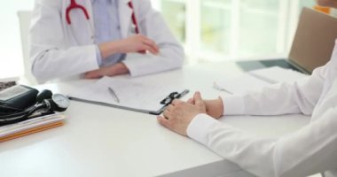Randevu sırasında klinikte hasta el ele tutuşan dost canlısı bir bayan doktor. Muayenenin sonucu pozitif test ve sakinlik.