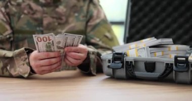 Ordu generali evrak çantasında dolarları sayıyor. Savaş ekonomisi, savaş ekonomisi ve milyarlarca dolar.