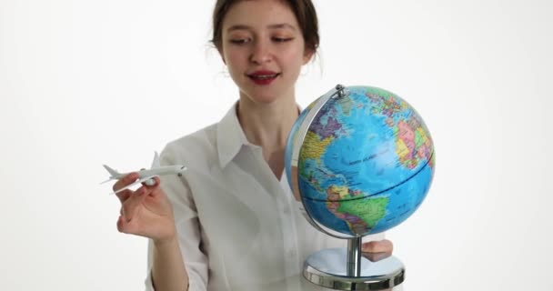 世界の飛行機を旅行し 航空券を販売 世界地図を手に飛行機や地球を保持する美しい女の子 — ストック動画