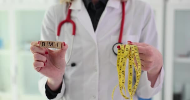 医師はBmiと測定テープを持っています 栄養士は健康的なライフスタイルを推奨します — ストック動画