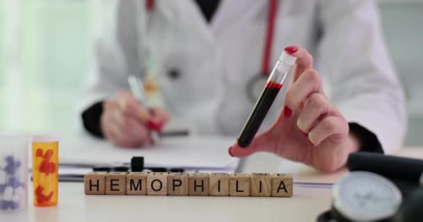Dokter Heeft Een Reageerbuis Met Bloed Ernaast Woord Hemofilie Concept — Stockvideo