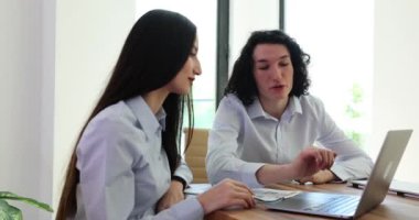 Erkek öğretmen dizüstü bilgisayarı gösteriyor, yeni çalışanlara öğretiyor ve kurumsal yazılıma yardım ediyor. Ciddi akıl hocası tren işçisi