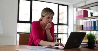 Dizüstü bilgisayar kullanan endişeli bir kadın gergin olur ve çivi çakar. Tedirgin kız, e-postadaki kötü haberlerle, tırnaklarını yiyerek ve ekranlara bakarak strese girdi.