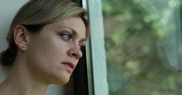 悲しい孤独な女が退屈して窓の外を見ている 感情的ストレスうつ病と孤独 — ストック動画