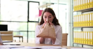 İş yerinde kese kağıdına nefes alan korkmuş bir kadın. İş yerinde panik atak.