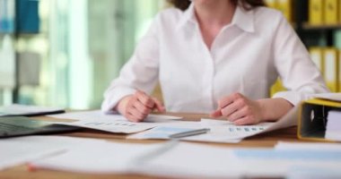 Kadın elleri yumruklara sıkışıyor ve iş evrakları masaüstünde. Öfke sorunları ekonomik kriz ve finansal çöküş iflas kavramı